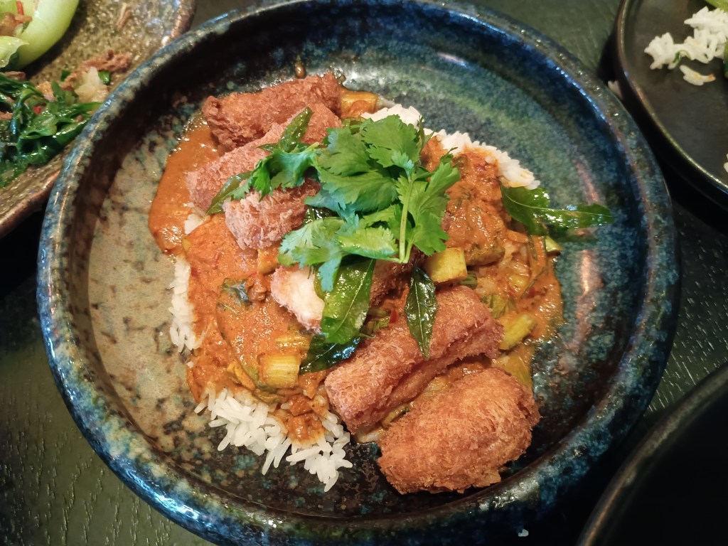 Golden fried king prawn katsu served with a rich rendang curry sauce, garnished with fresh coriander and sliced red chilli